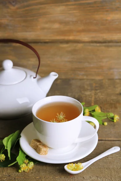 Sabroso té de hierbas con flores de tilo en la mesa de madera —  Fotos de Stock