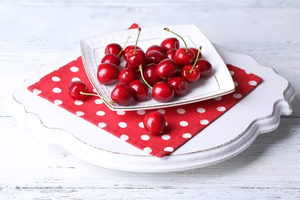 Sweet cherries on plate on wooden background — Stock Photo, Image