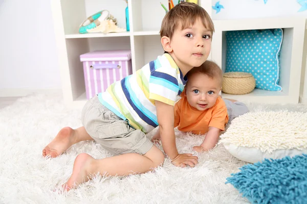 Lindos niños pequeños en el piso en la habitación —  Fotos de Stock