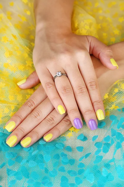 Mano femenina con uñas elegantes y coloridas, sobre fondo brillante —  Fotos de Stock