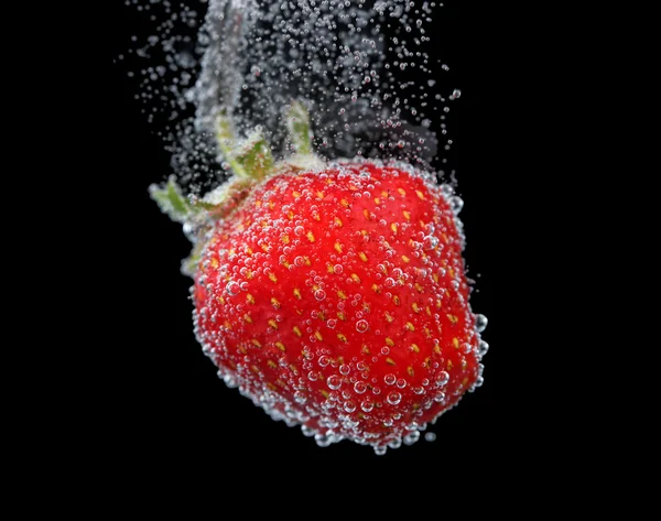 Beautiful strawberry in water with bubbles, on black background — Stock Photo, Image