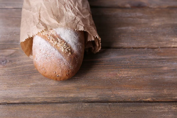 Pão em saco de papel no fundo de madeira — Fotografia de Stock