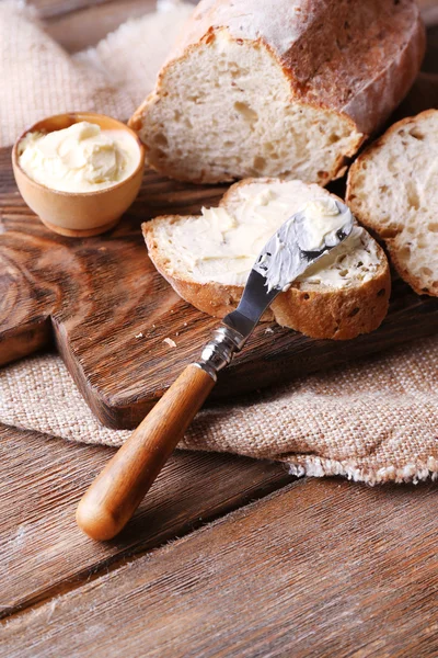 Fresh bread and homemade butter on wooden background — Stock Photo, Image