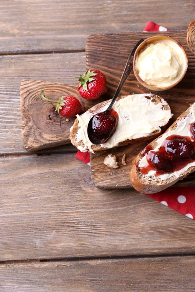 Tostadas frescas con mantequilla casera y mermelada de fresa sobre fondo de madera —  Fotos de Stock