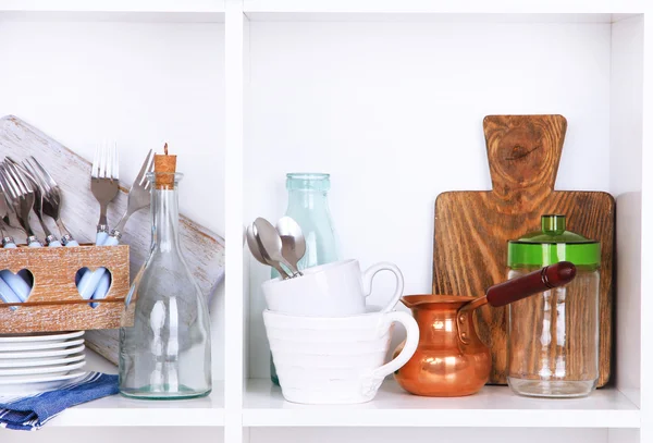 Kuchyňské potřeby a nádobí na krásné bílé police — Stock fotografie