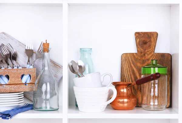 Utensílios de cozinha e utensílios de mesa em belas prateleiras brancas — Fotografia de Stock