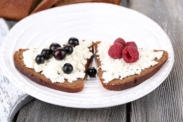 Bread with cottage cheese and berries on plate close-up — Stock Photo, Image