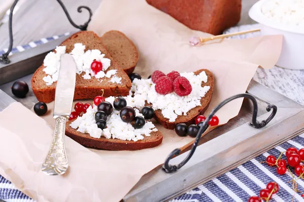 Bread with cottage cheese and berries on wooden tray close-up — Stock Photo, Image