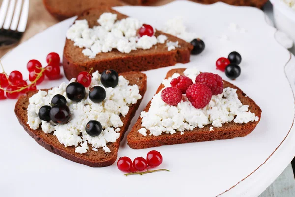 Bread with cottage cheese and berries on wooden tray close-up — Stock Photo, Image