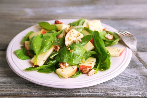Salada verde com maçãs, nozes e queijo sobre fundo de madeira — Fotografia de Stock
