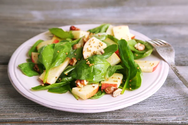 Salade verte aux pommes, noix et fromage sur fond bois — Photo