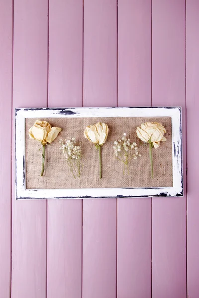 Wooden frame with dried flowers on wooden background — Stock Photo, Image