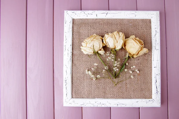Wooden frame with dried flowers on wooden background — Stock Photo, Image