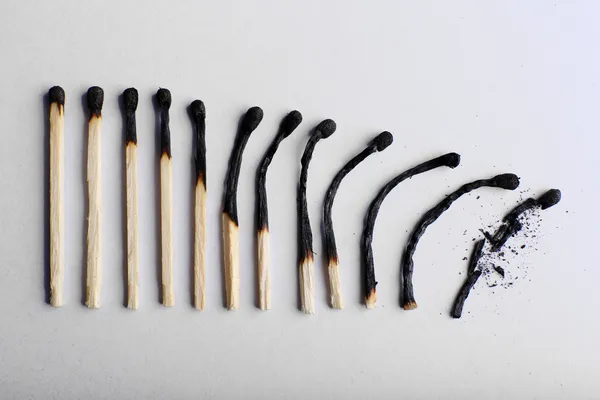 Matches in different stages of burning, on color background — Stock Photo, Image