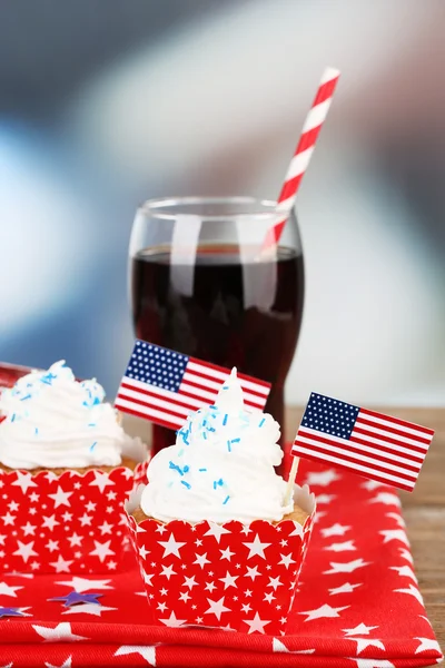 Cupcakes americanos de férias patrióticas e copo de cola na mesa de madeira — Fotografia de Stock