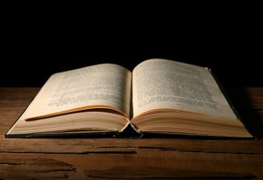 siyah arka plan üzerine masada eski kitap