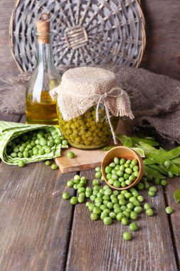 ahşap zemin üzerine peçete üzerinde taze ve konserve bezelye kase ve Cam Kavanoz