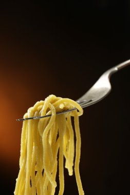 İtalyan makarna spagetti çatalı koyu arka plan üzerinde