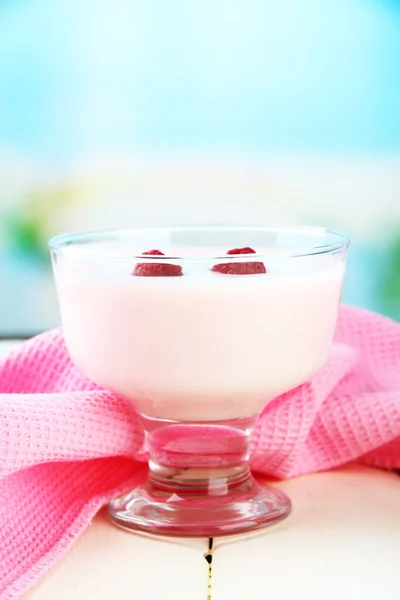 Iogurte delicioso com bagas na mesa em fundo brilhante — Fotografia de Stock