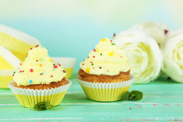 Leckere Tasse Kuchen mit Sahne auf blauem Holztisch — Stockfoto