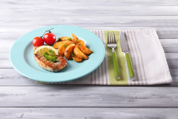 Bife grelhado, legumes grelhados e pedaços de batata frita na mesa, no fundo brilhante — Fotografia de Stock