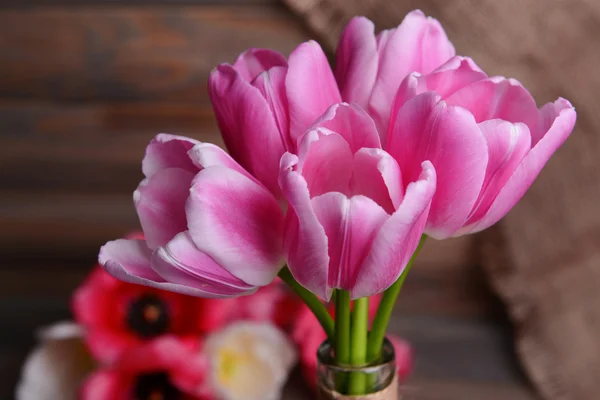 Vackra tulpaner i hink i vas på bordet på grå bakgrund — Stockfoto