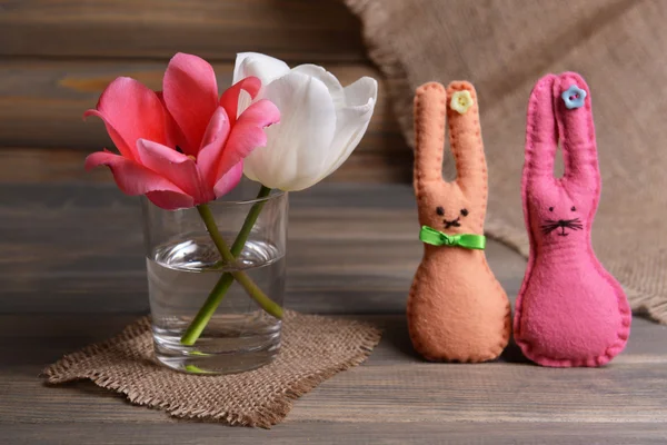 Hermosos tulipanes en cubo en jarrón sobre mesa sobre fondo gris —  Fotos de Stock