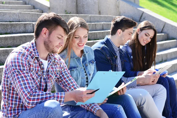 Uczniowie siedzący na schodach w parku — Zdjęcie stockowe