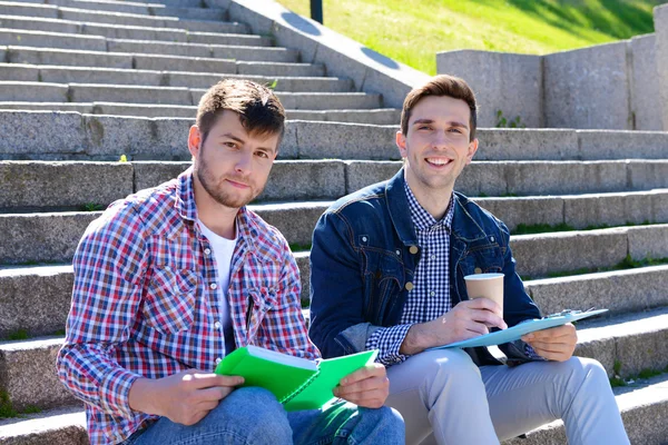 Studenti sedí na schodech v parku — Stock fotografie