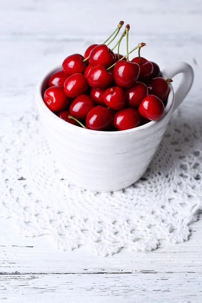 Sweet cherries in mug on wooden background — Stock Photo, Image