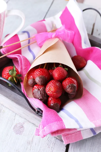 Căpșuni în ciocolată pe frigărui în pungă de hârtie pe masă aproape — Fotografie, imagine de stoc