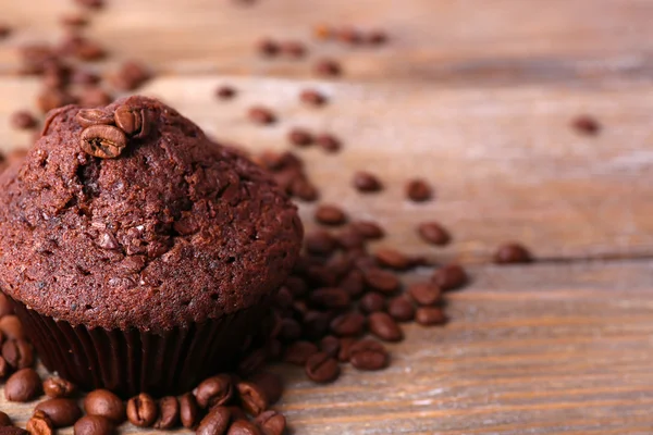 Muffin de chocolate y granos de café sobre fondo de madera —  Fotos de Stock