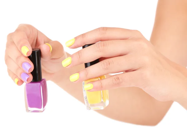 Manos femeninas con elegantes uñas de colores sosteniendo botella con esmalte de uñas, aislado en blanco — Foto de Stock