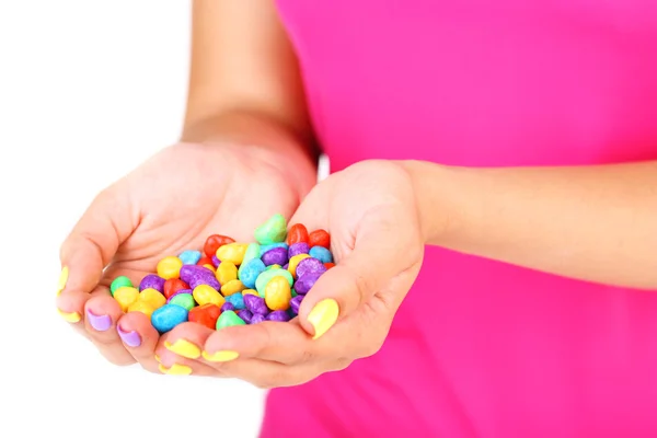 Manos femeninas con elegantes uñas coloridas sosteniendo caramelos multicolores, de cerca, aisladas en blanco — Foto de Stock