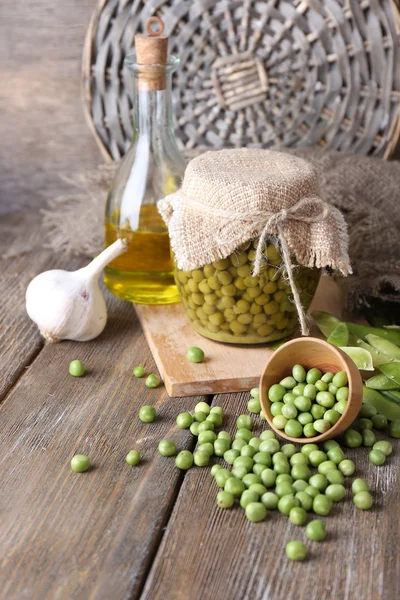 Vers en Ingeblikte erwten in kom en glazen pot op servet, op houten achtergrond — Stockfoto