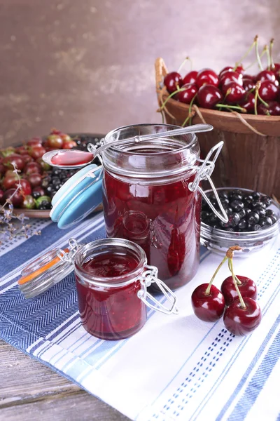 Berries jam in glass jar on table, close-up