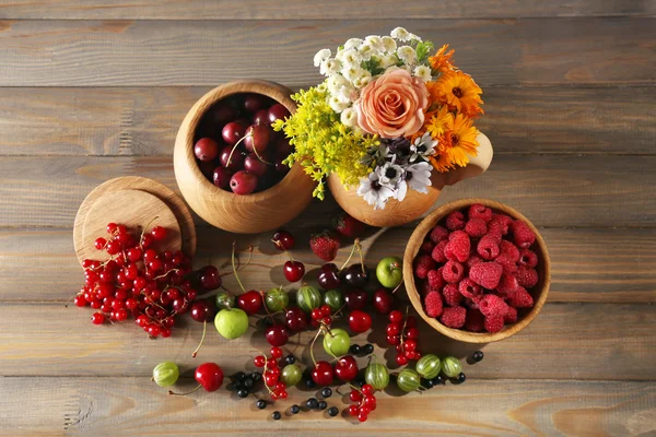 果実と木製のテーブルの上に花のある静物 — ストック写真