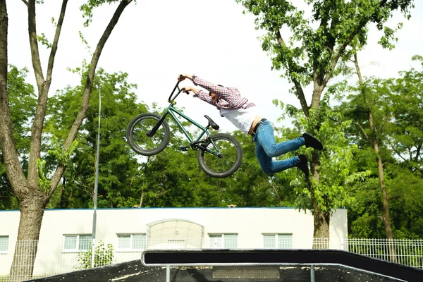 Joven saltando con su BMX Bike en el skate park — Foto de Stock