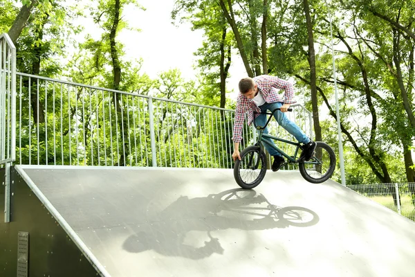 Мальчик прыгает на велосипеде BMX в скейт-парке — стоковое фото