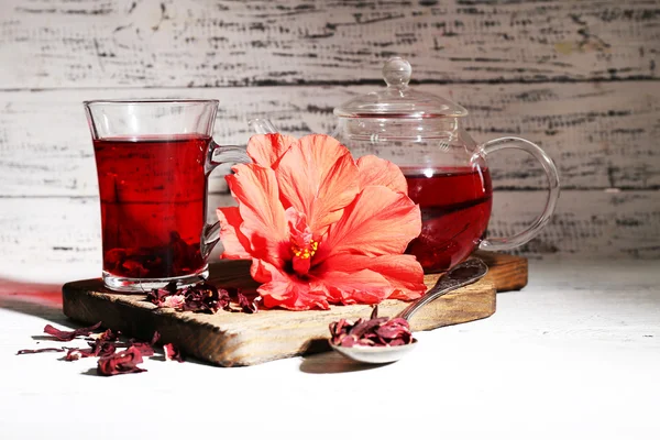 Chá e flor de hibisco a bordo, sobre fundo de madeira — Fotografia de Stock