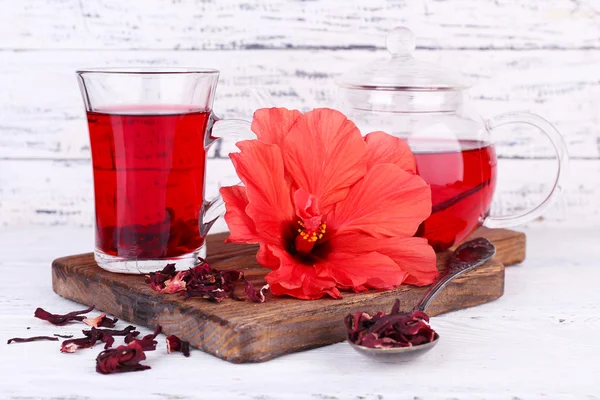 Hibiscus tea and flower on board, on wooden background — Stock Photo, Image