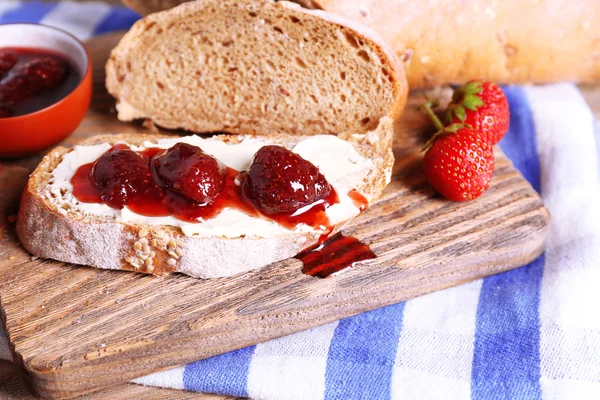 Fresh toast with homemade butter and strawberry jam on wooden background — Stock Photo, Image