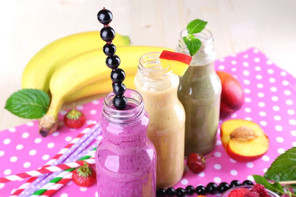 Bottles of delicious smoothie on table, close-up — Stock Photo, Image