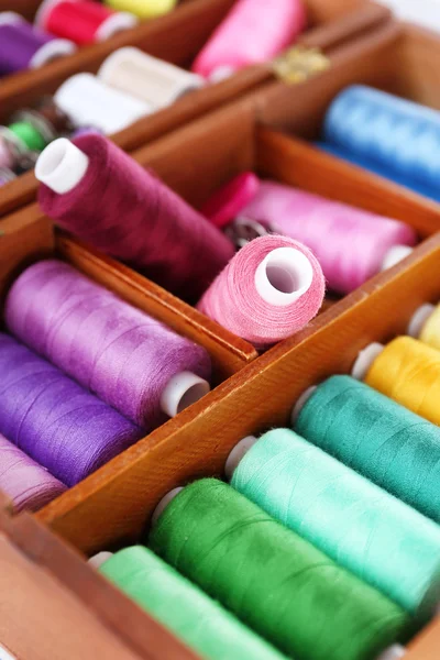 Hilos de colores para la costura en caja de madera de cerca —  Fotos de Stock