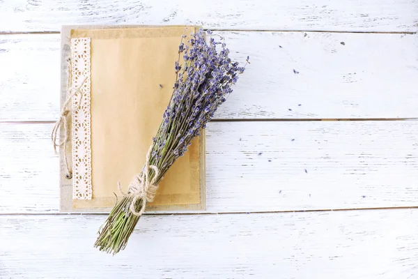 Flores de lavanda y viejo álbum de fotos sobre fondo de madera — Foto de Stock