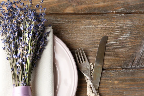 Apparecchiatura tavolo da pranzo con fiori di lavanda su sfondo tavolo di legno — Foto Stock