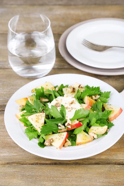 Insalata verde con mele, noci e formaggio su fondo di legno — Foto Stock