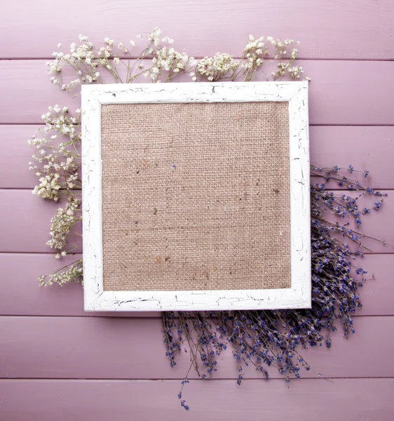 Wooden frame with dried flowers on wooden background — Stock Photo, Image