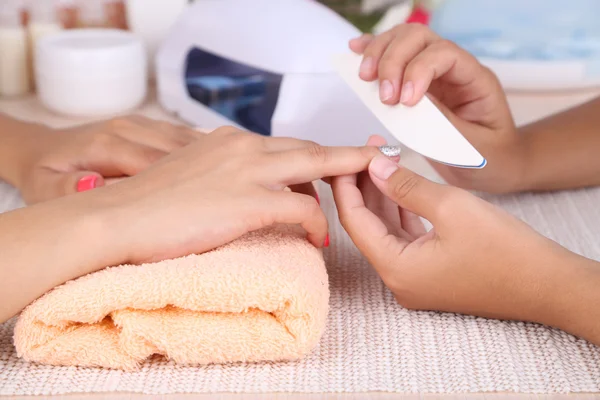 Jovem mulher está recebendo manicure no salão de beleza, close-up — Fotografia de Stock