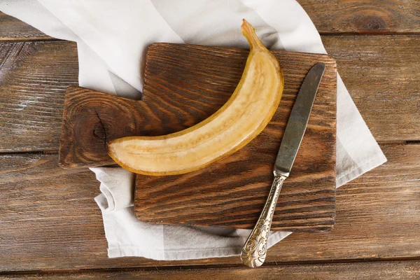 Banana madura cortada pela metade no fundo de madeira — Fotografia de Stock
